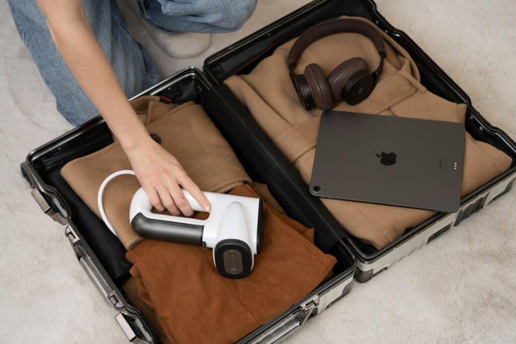 traveler packing laptop camera in carry-on backpack”