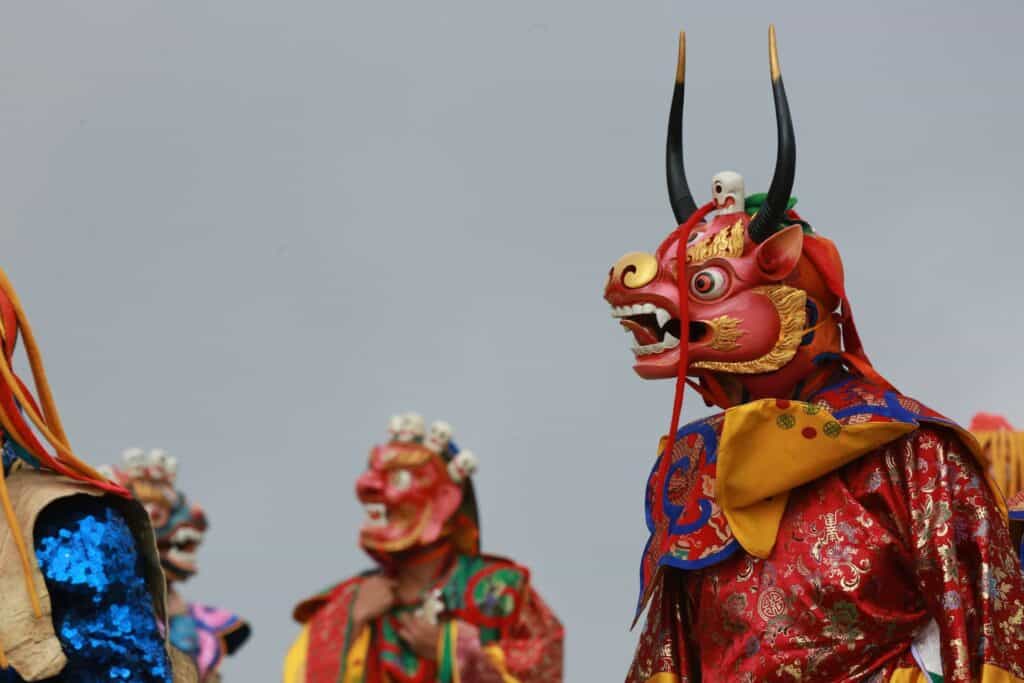 Bhutan Tsechu festival masked dancers traditional costumes spinning stamping