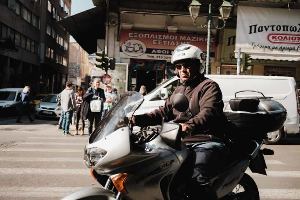 A rider cautiously looking both ways before moving through an intersection.