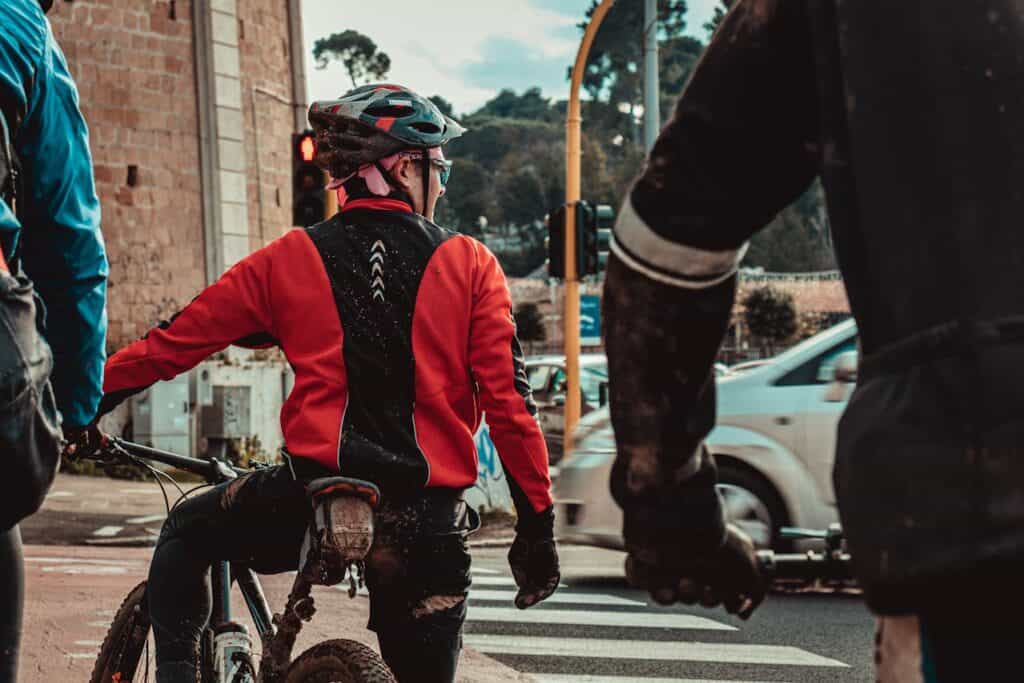 A bicyclist waiting at a red light in a city setting.