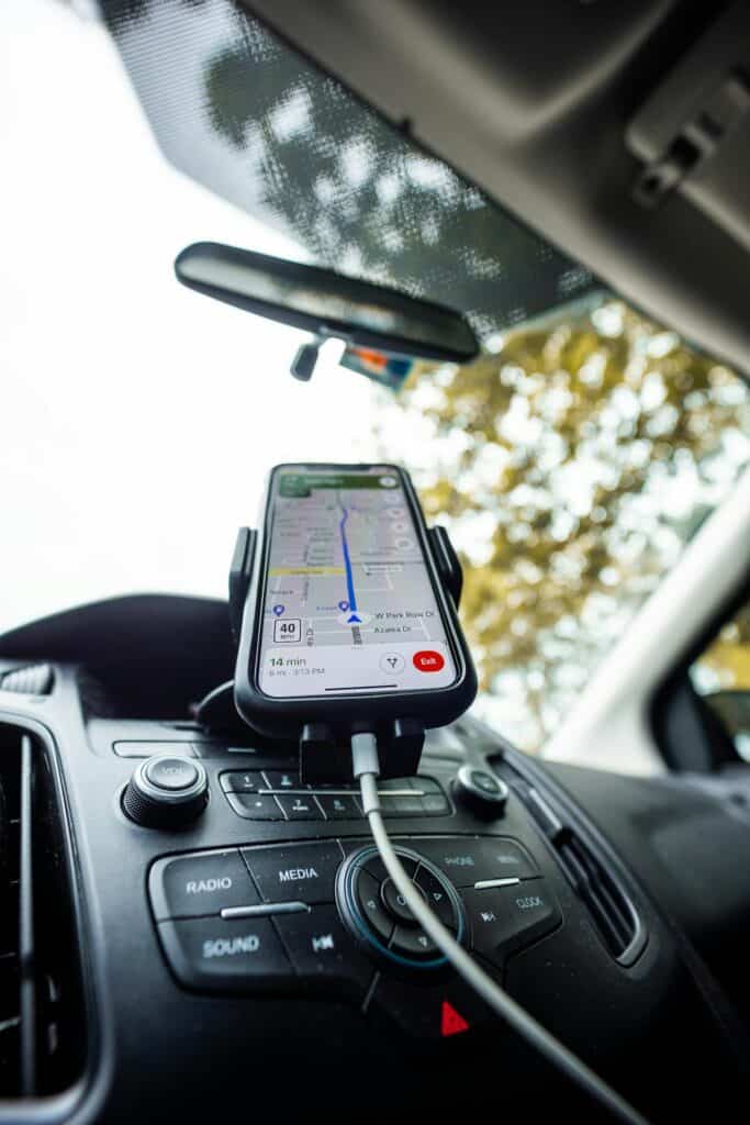 Smartphone mounted on a car dashboard for navigation.