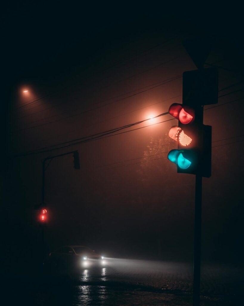 Traffic light on road at night