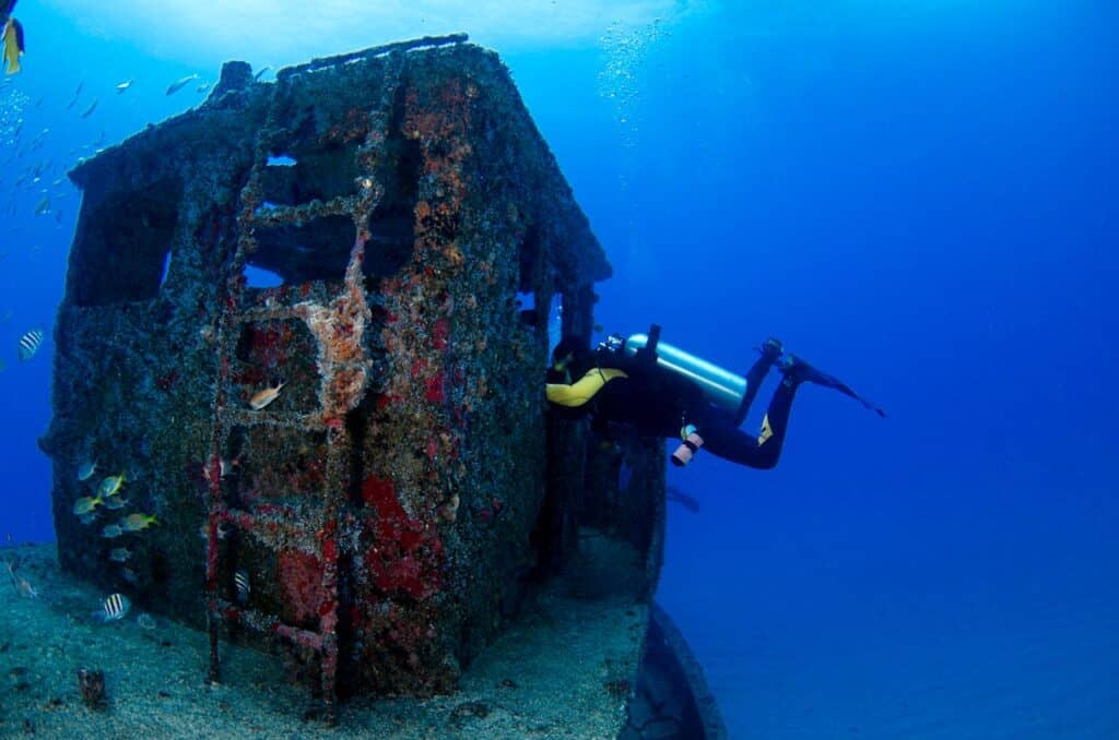 scuba divers observing shipwreck exterior without entering