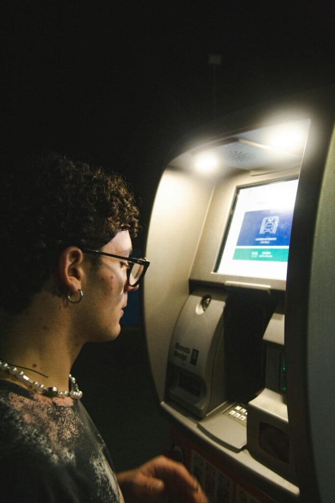 Man Using ATM Machine at Night