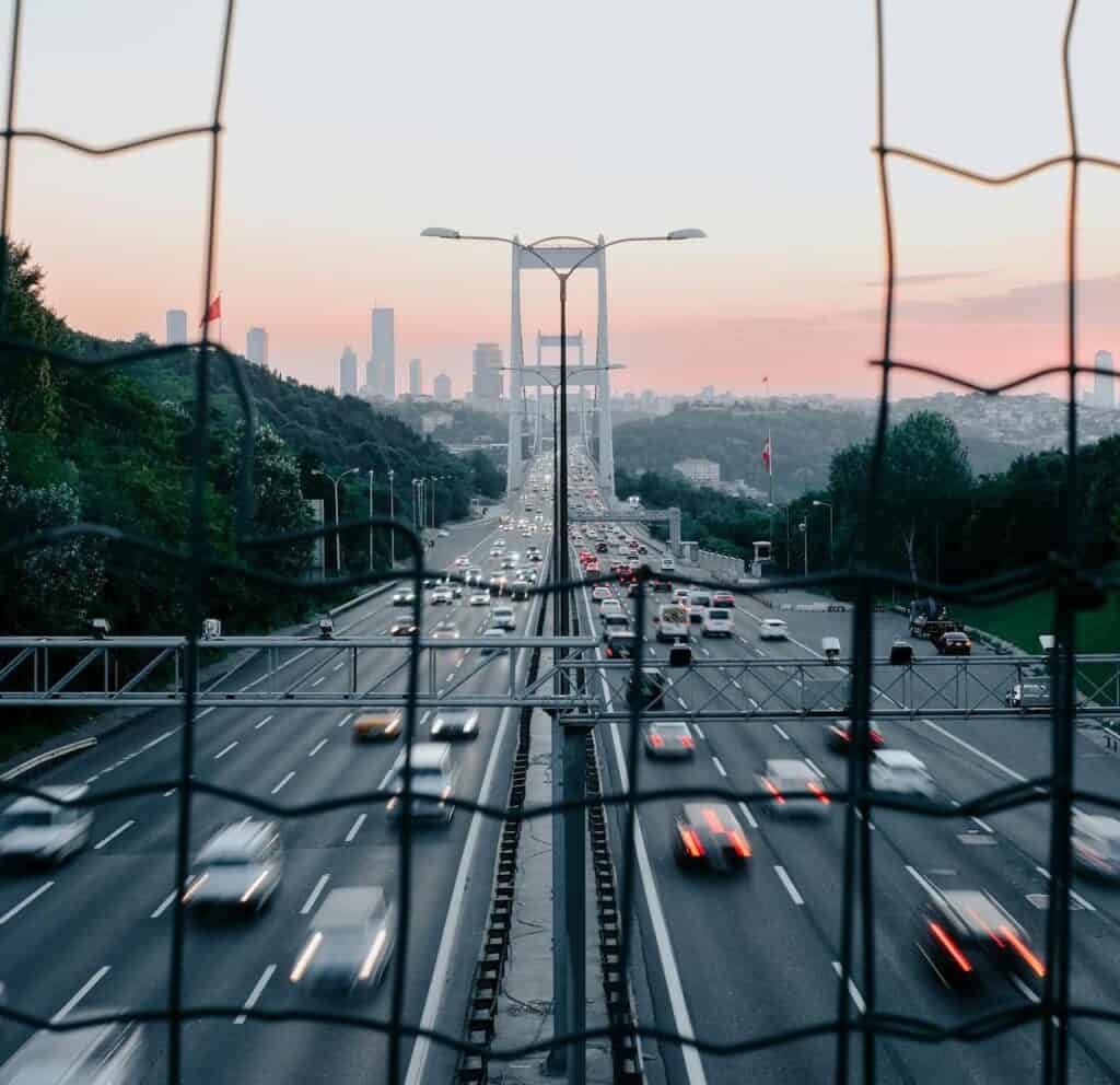 Busy highway with multiple cars weaving aggressively through lanes