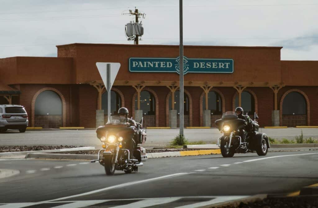 Two Men Riding on Touring Motorcycle Near Painted Desert Store in Young, AZ, United StatesTwo Men Riding on Touring Motorcycle Near Painted Desert Store in Young, AZ, United States