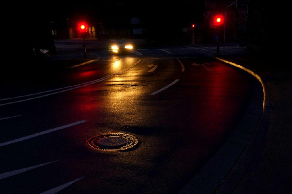 Traffic camera flash catching a vehicle at a red light