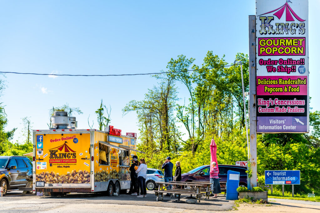 Waynesboro, USA - May 8, 2021: Town city in rural Virginia with sign for King's gourmet popcorn store shop food truck building near Blue Ridge Parkway