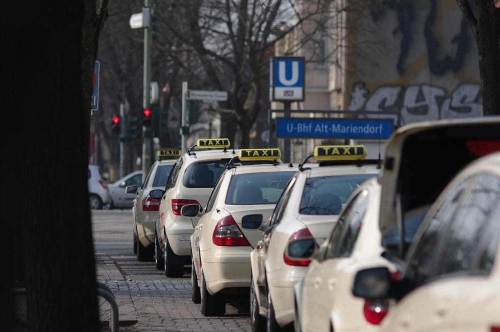 people offering taxis to travelers at airport arrivals