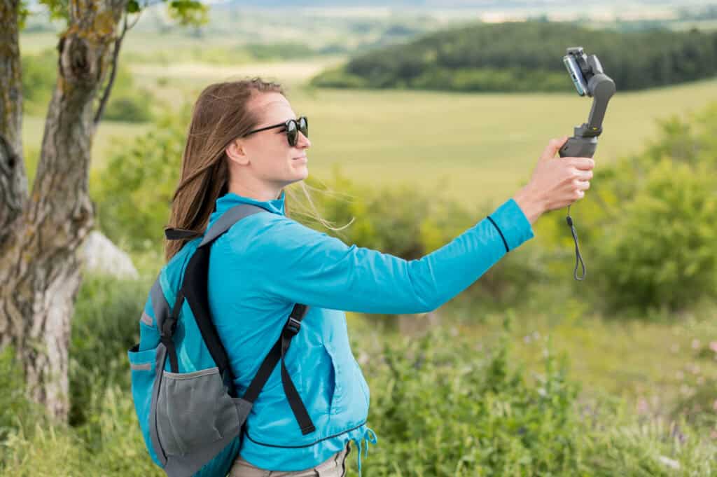 person recording travel video on phone with gimbal