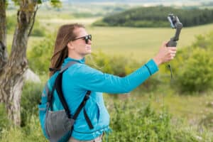 person recording travel video on phone with gimbal