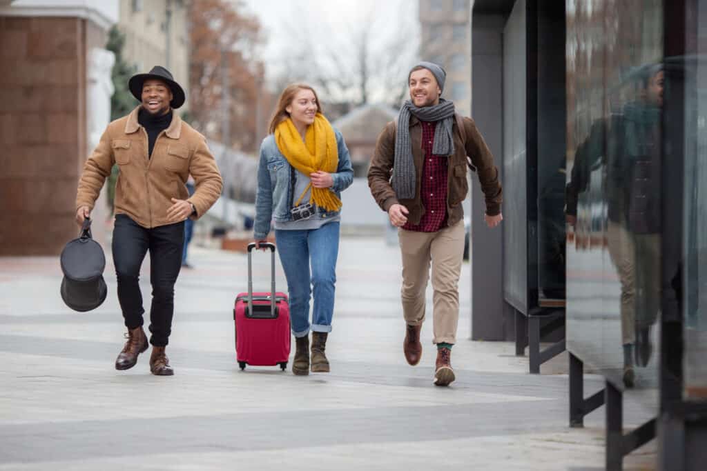 international students with suitcases on campus walkway