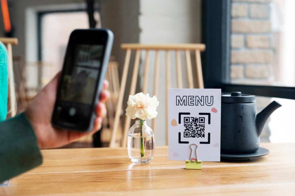 QR code menu on a restaurant table with a smartphone scanning it