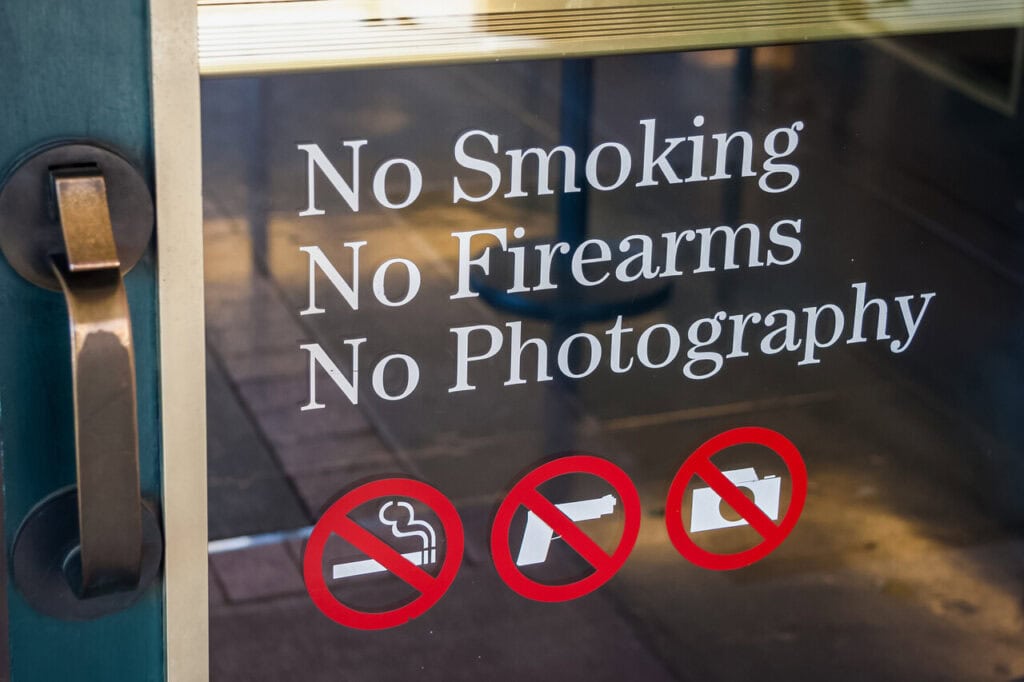 A “No Firearms Allowed” sign posted on a storefront.