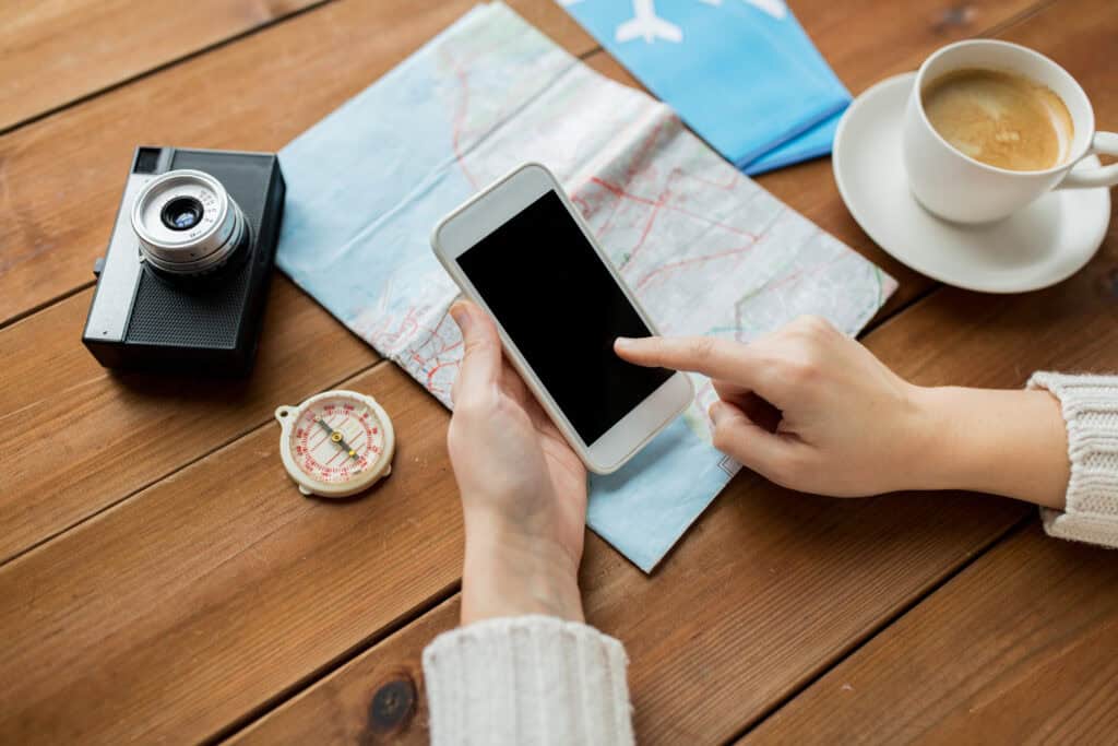 traveler planning trip with coffee map and phone on table