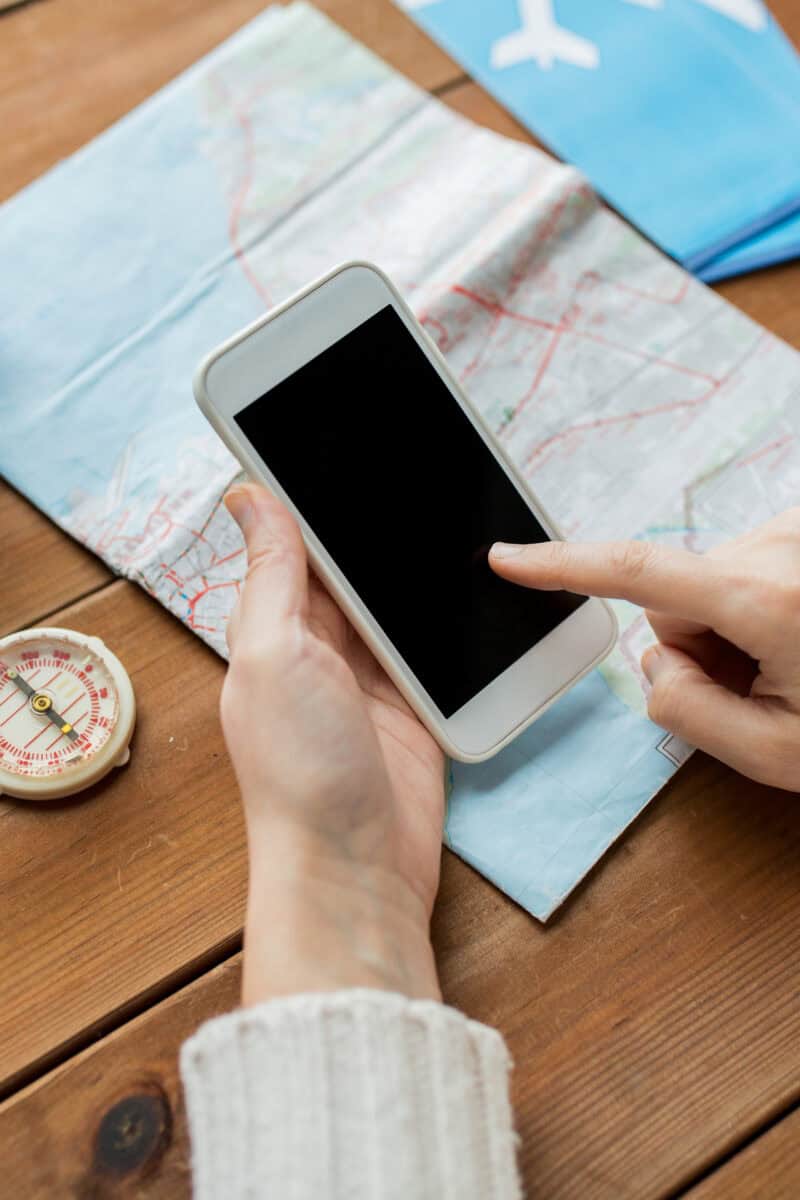 traveler planning trip with coffee map and phone on table