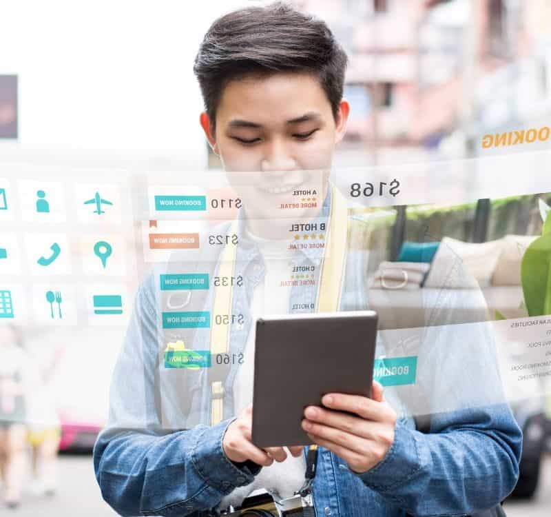 Asian tourist backpacker using mobile appication technology booking hotel online while traveling on vacations, selective focus