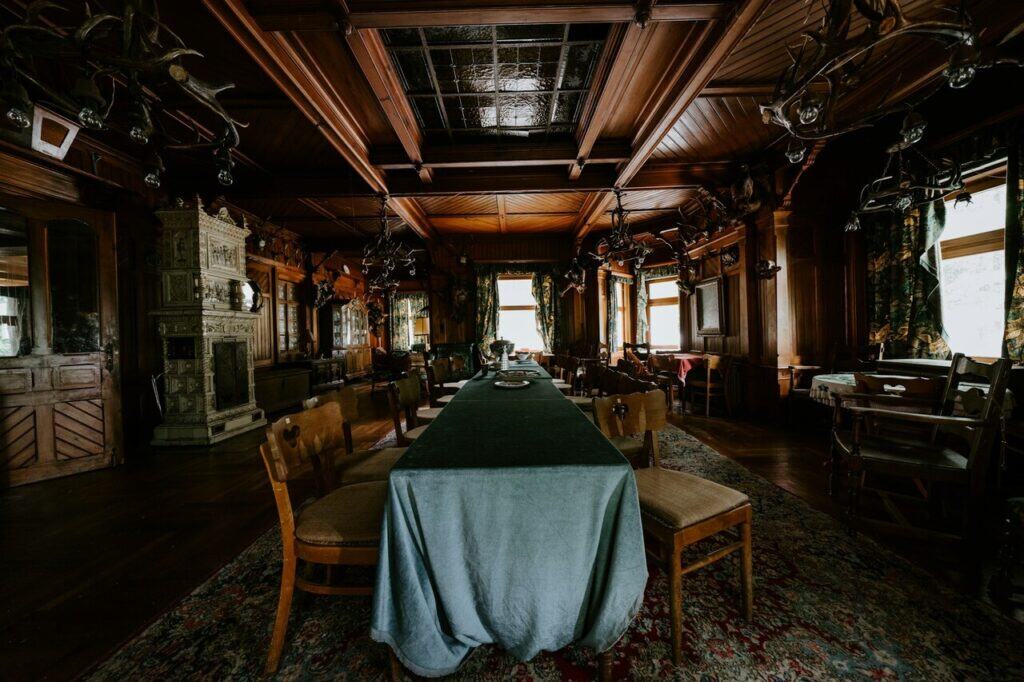 A long, empty dining hall with antique decor