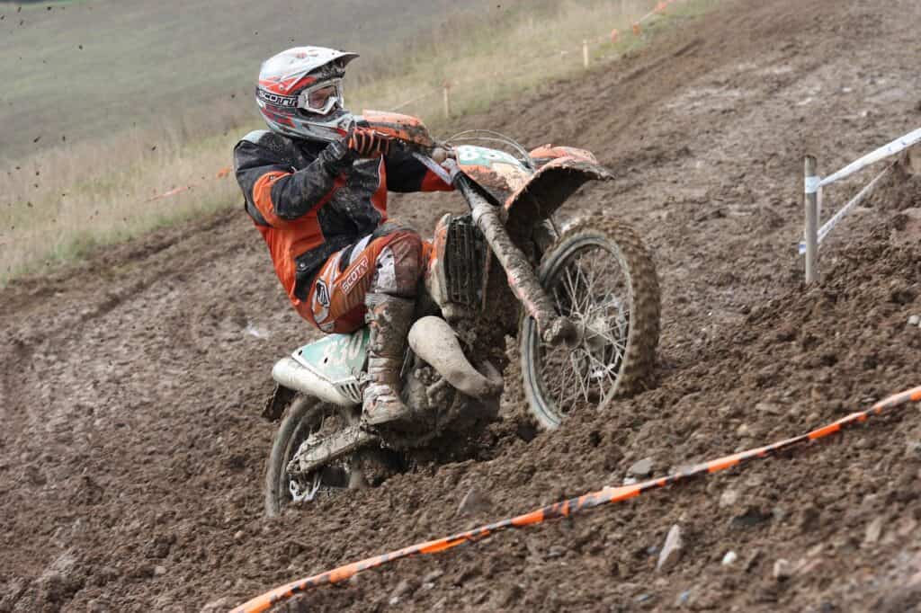 "Motorcyclist standing on pegs off-road