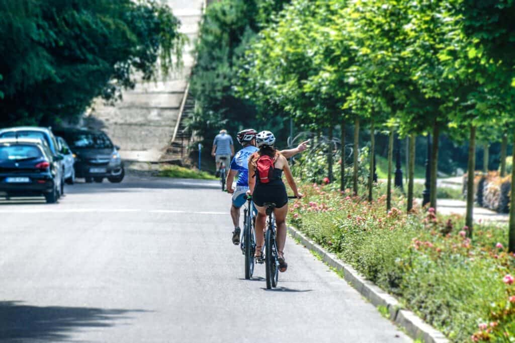 e-bike riders on a tree-lined European boulevard