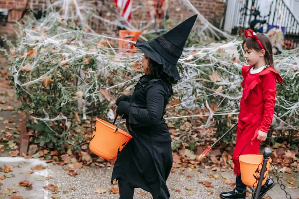 Kids walking down a suburban street lined with Halloween decorations.