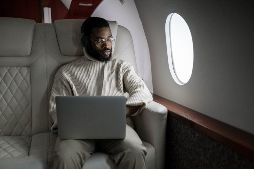 Traveler enjoying extra leg space with a laptop.