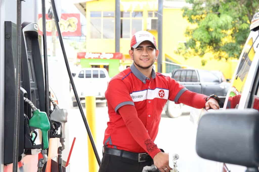 Gas station attendant refueling a car