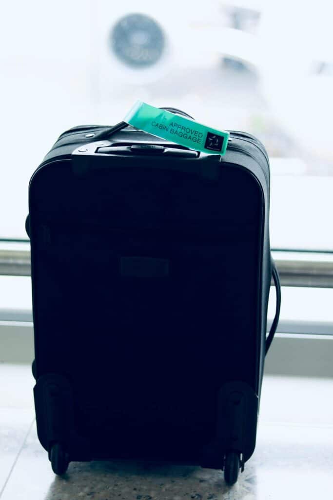 A close-up of a red “Fragile” luggage tag attached to a suitcase