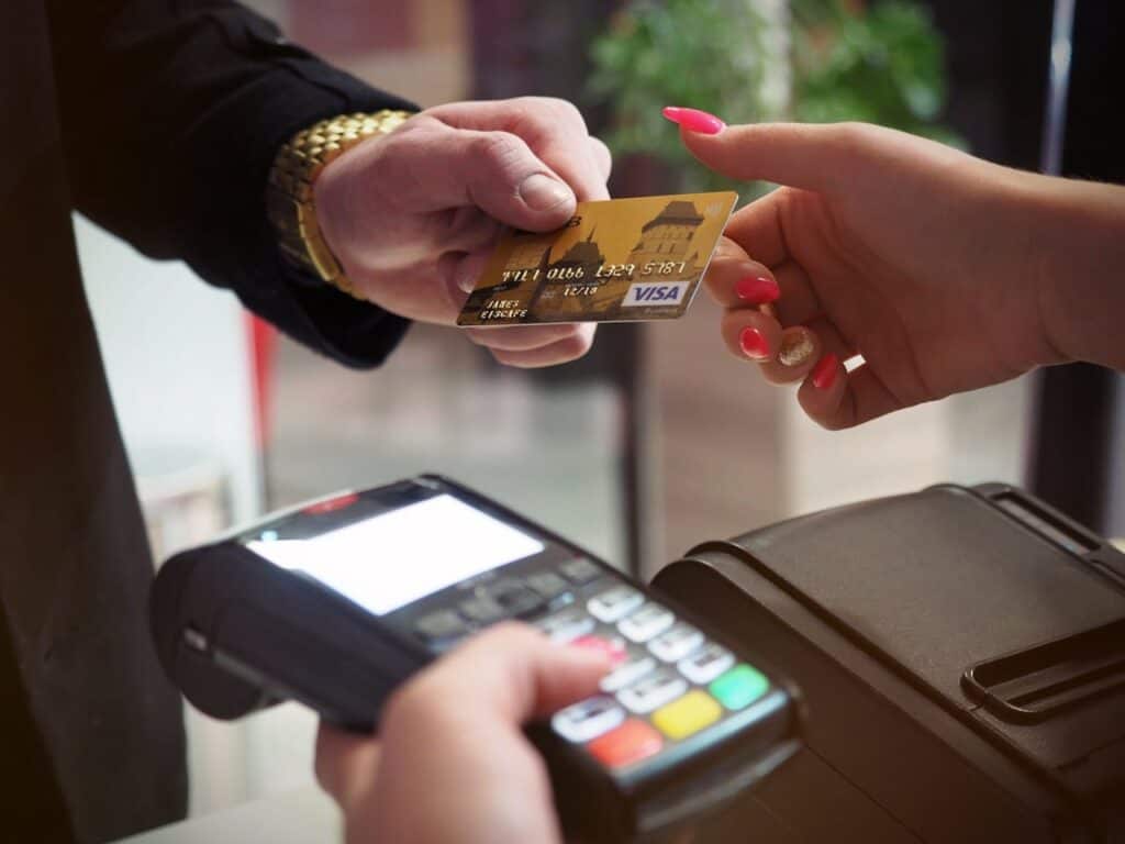 Customer tapping a smartphone or contactless card at a restaurant terminal