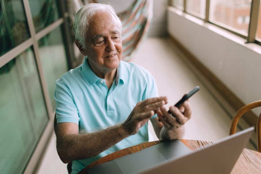 A retiree using a laptop to compare cruise costs or loyalty programs.