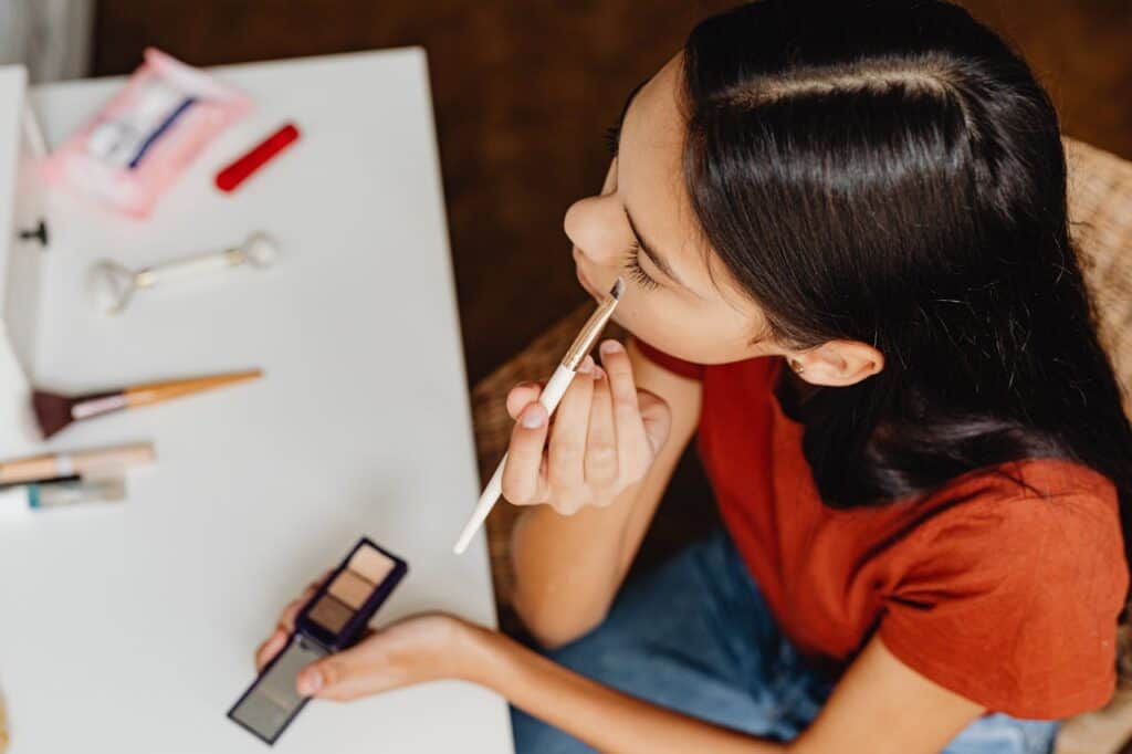 A person applying hair dye or doing nails at home with DIY products.