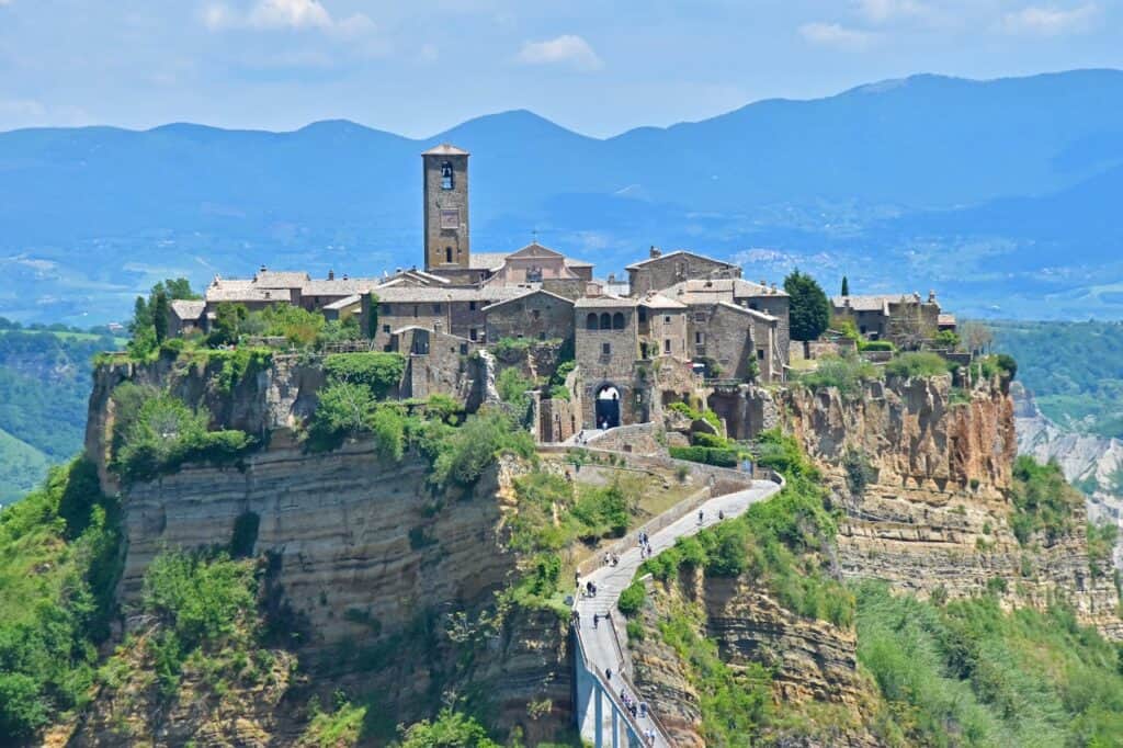 tourists walking across the long pedestrian bridge toward Civita di Bagnoregio