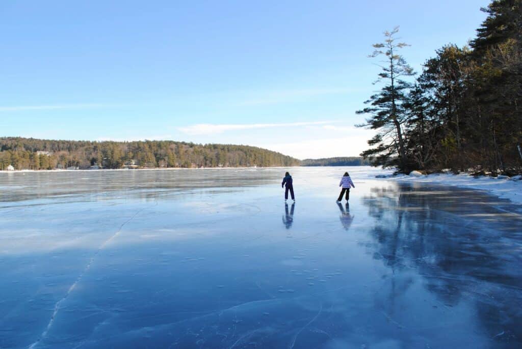skier gliding beside frozen lake