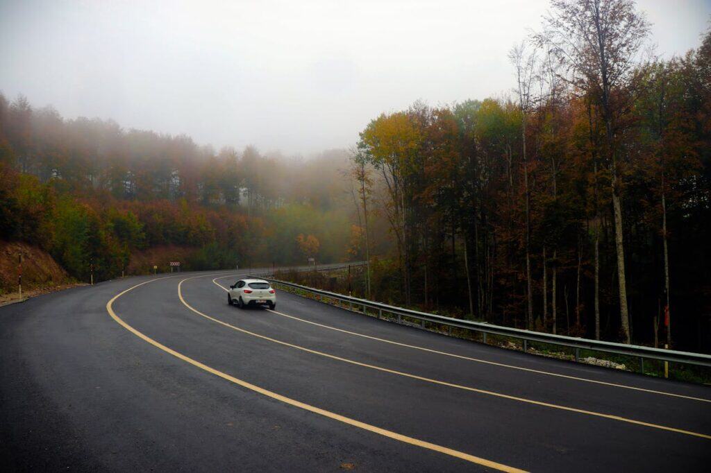 A car on an open road at dawn.