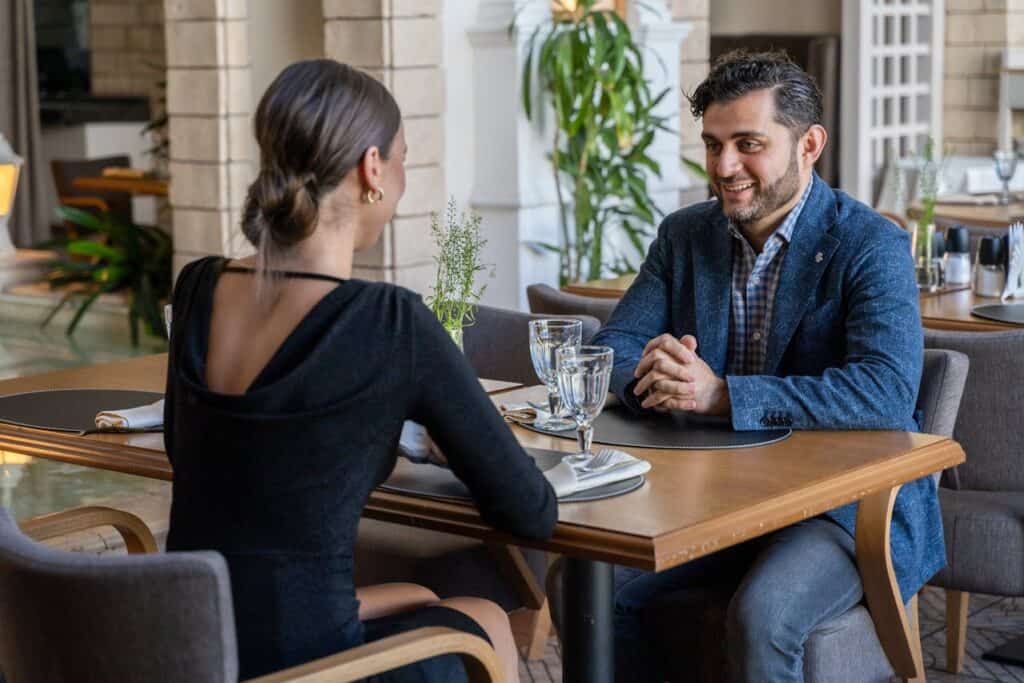 A couple dressed formally entering a fine-dining restaurant.