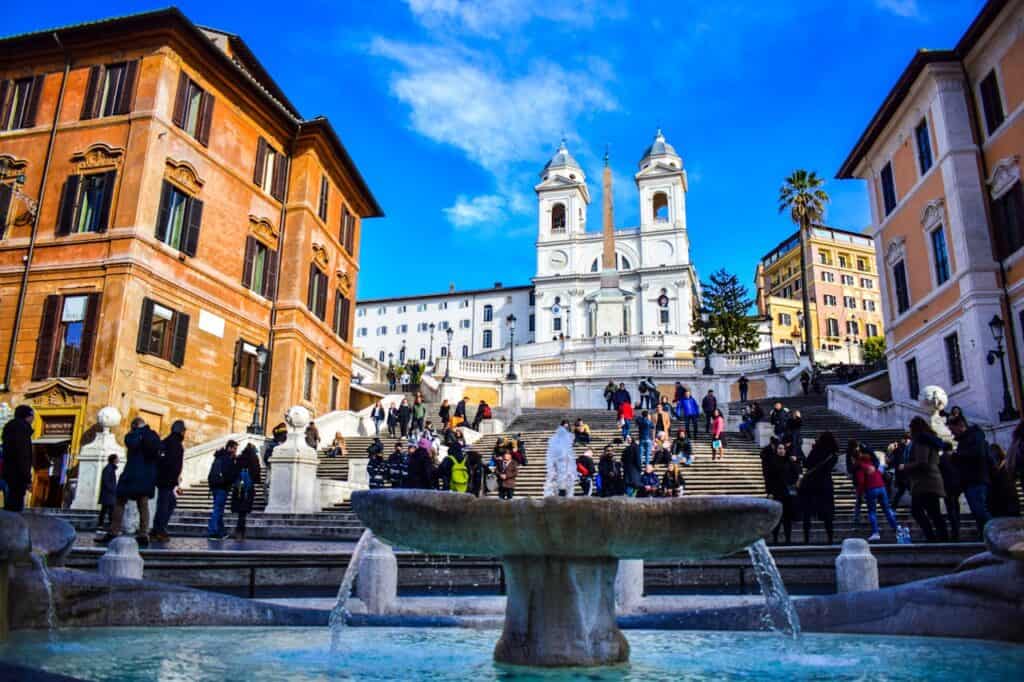Ancient Spanish Steps in Rome, Italy, with visitors and Twin Churches in the background.