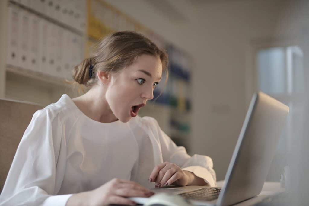 Traveler shocked while looking at final booking cost on screen.
