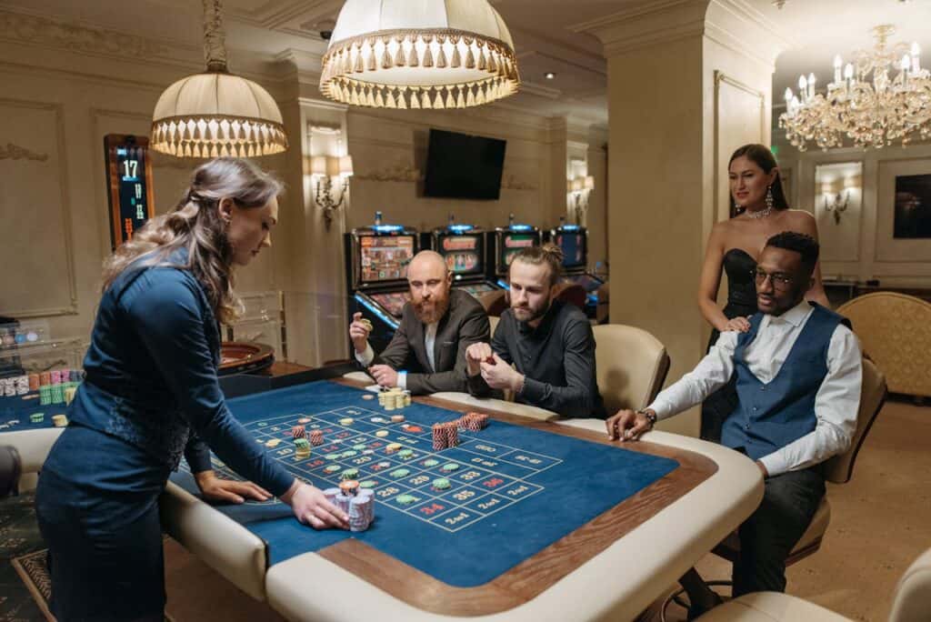 A casino dealer dealing cards at a busy poker table.