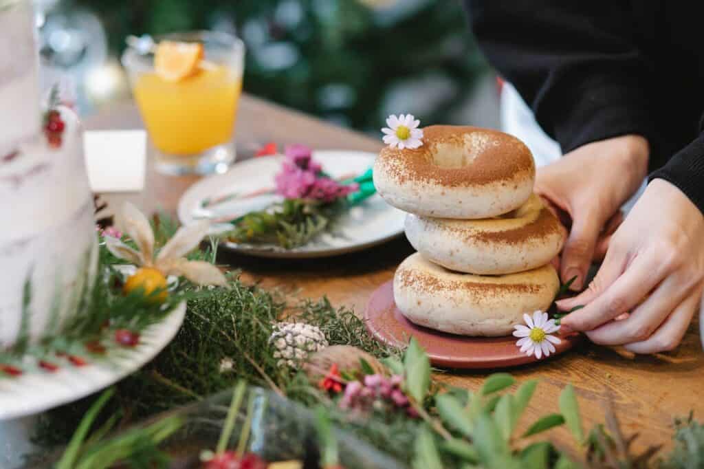 Bakers frosting or decorating donuts in an artisanal kitchen