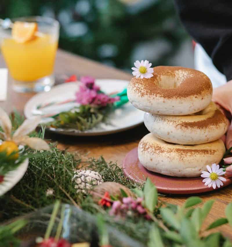 Bakers frosting or decorating donuts in an artisanal kitchen