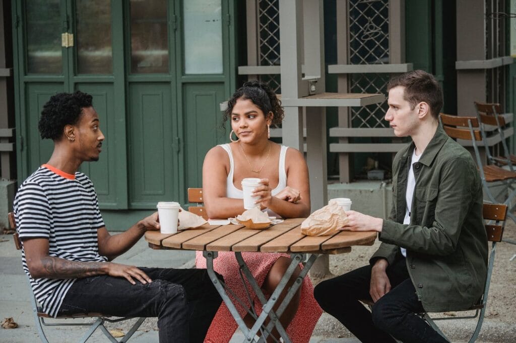 Two people having a friendly, casual chat at a park or café.