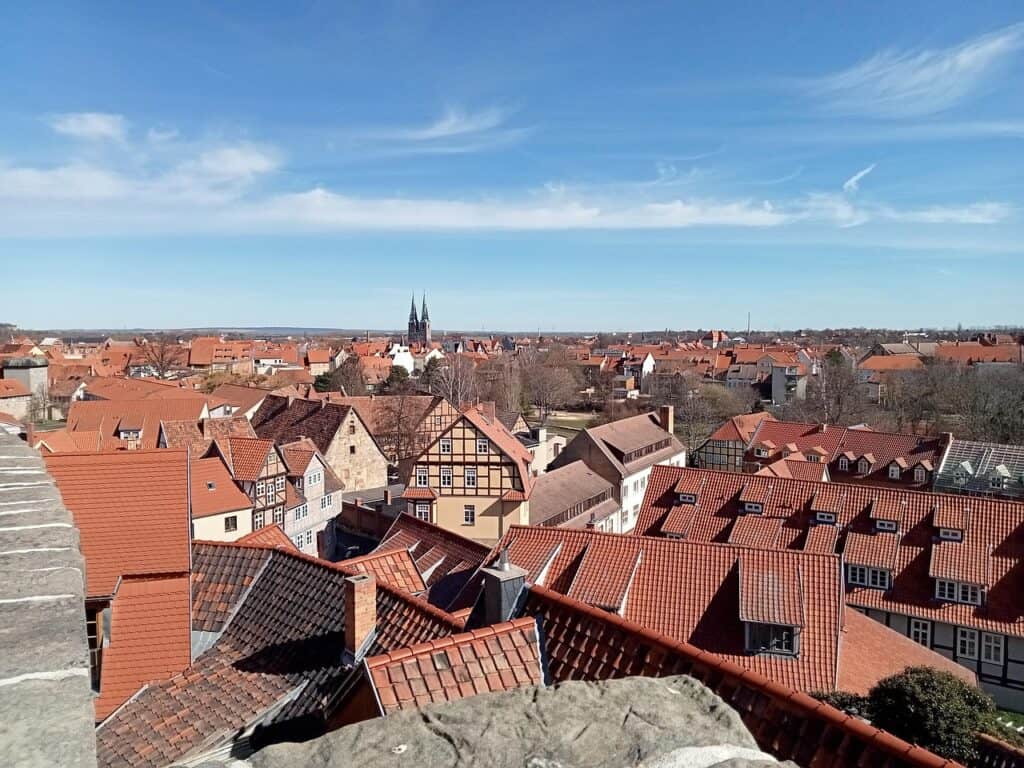 Rooftop view of a charming European town with historic buildings and church spires, sunny sky, and clear weather.