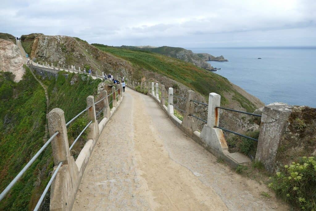Scenic coastal pathway at the Cliffs of Moher in Ireland with visitors walking along the trail.