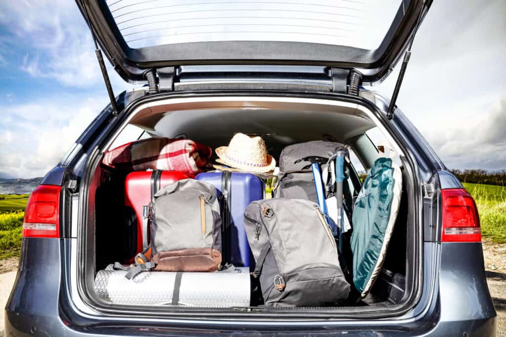 a car packed with gear driving toward open sky, symbolizing freedom and preparedness.