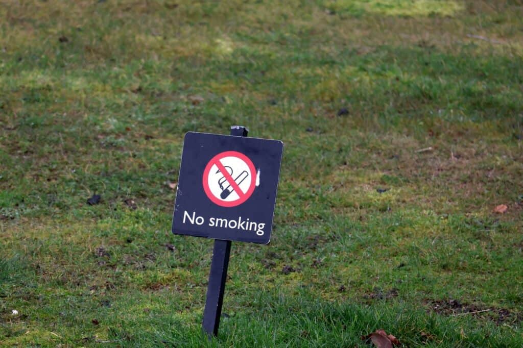 Public park or street with clear “No Smoking” or “No Alcohol” signage.