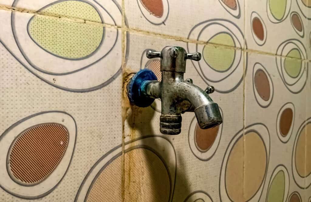 Close-up of a broken faucet, cracked tile, or dirty bedding in a rental.
