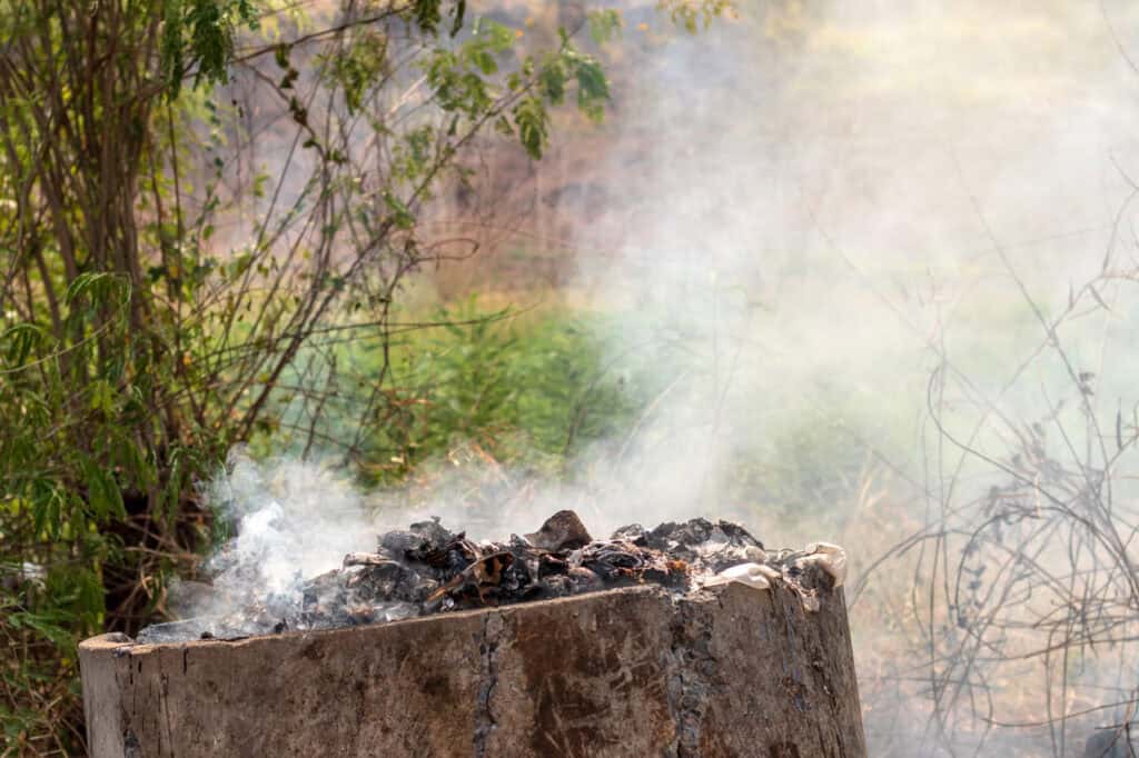 A fire pit with leftover trash inside.