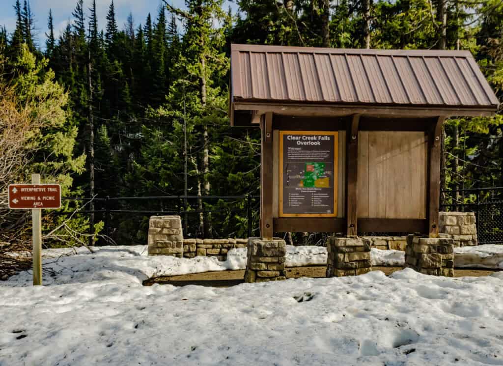 A wide shot of a trailhead signboard with clear difficulty ratings and maps.