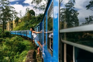 The girl travels by train to beautiful places. Beautiful girl traveling by train among mountains. Travel by train. Traveling to Asia. Trains Sri Lanka. Railway transport. Railway. Transport Asia
