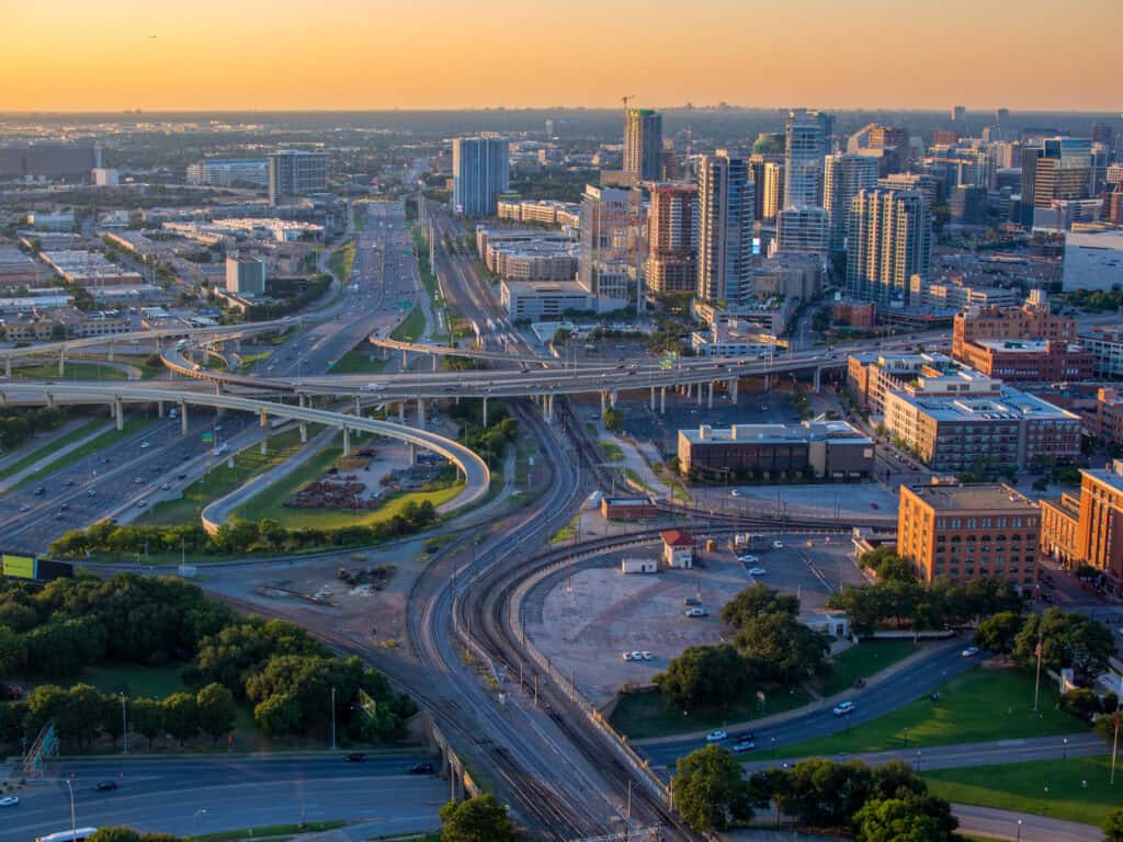 Experience a piece of American history with this stunning aerial view from the Reunion Tower of the Texas School Book Depository, the site where President John F. Kennedy was tragically assassinated in 1963. Captured from above, this image showcases the vibrant city of Dallas, Texas, with its bustling highways and towering skyscrapers, offering a unique perspective of this historical location. The composition of this photograph provides a powerful visual representation of the intersection of history and modern urbanization, making it the perfect addition to any editorial, documentary or news project.